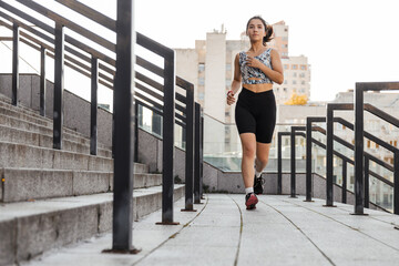 Obraz premium Teenage girl doing jogging near stadium outdoors of the city background