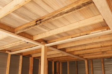 Fototapeta na wymiar Wooden floor. Wooden ceiling. Wooden construction. Wood Gilders of fresh wood on the roof.