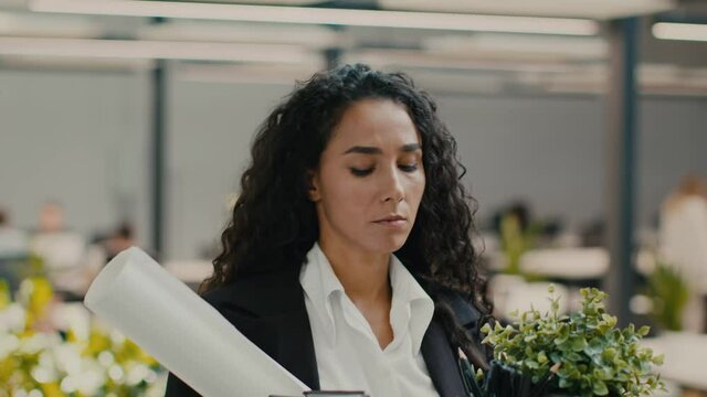 Fired Female Employee Walking With Cardboard Box Leaving Office