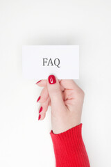 Woman holding card with FAQ Frequently Asked Questions text