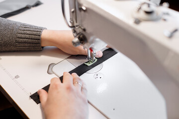 a man behind a sewing machine in the work close-up in the sewing industry. seamstress