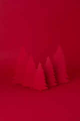 Christmas creative concept. Red Christmas tree of paper on the red background. Holiday concept.