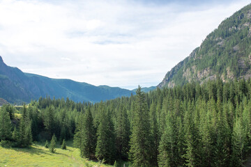 peaks of mountains against a blue sky with white clouds. Summer clear sunny day