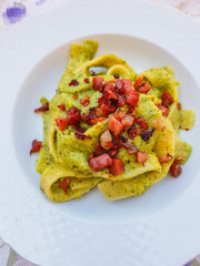 Pappardelle con pesto di basilico e pancetta fotografate dall'alto