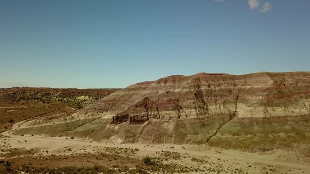 Aerial: Scenic Shot Of Rock Formations Against Sky, Drone Flying Over Plants On Sunny Day - Paria River, Colorado