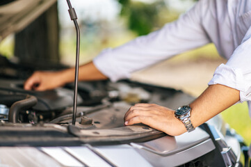 Man opens the hood of a car to fix the car.