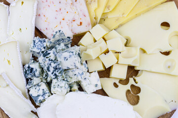 Different kinds of cheese on a cutting board. Close-up