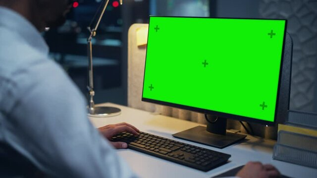 Close Up of a Businessman Working on Desktop Computer with Chroma Key Green Screen Mock Up Display. Male Executive Director Managing Digital Projects, Typing Data, Using Keyboard and Mouse.