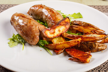 Salsicce cotte alla griglia con patate al forno e rucola