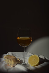Still-life. Beautiful glass, lemon and clam shell on a dark background