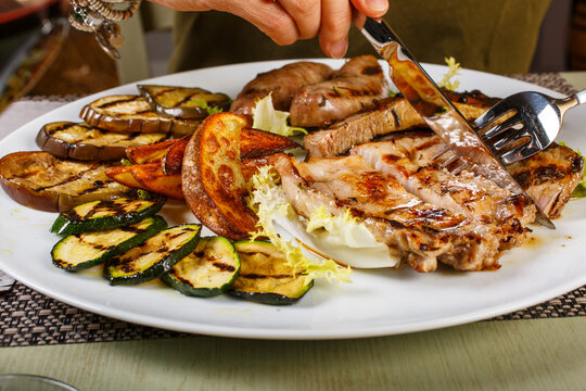 Misto di carne servito in un ristorante con verdure grigliate, patate al forno e insalata