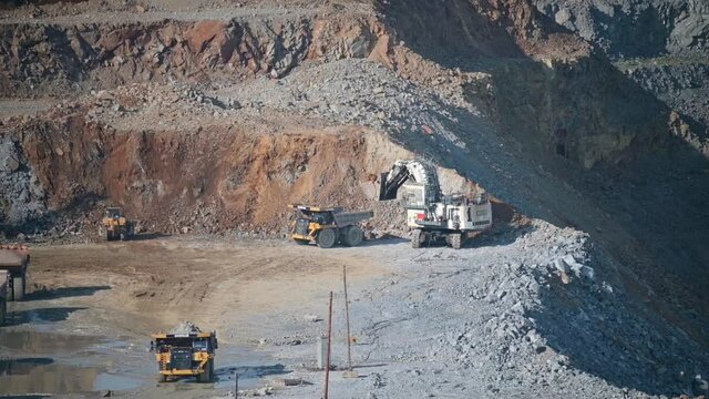 Russia, Amur region, July 7, 2021. Quarry, open pit mining, gold ore mining. The ore is loaded by a Liebherr excavator into a Caterpillar truck from the quarry. Summer.
