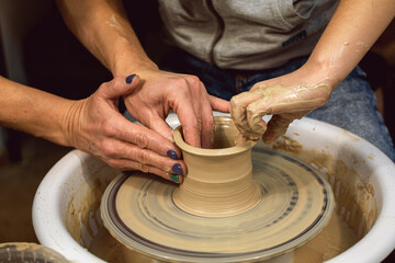 Master class on modeling of clay on a potter's wheel. In the pottery workshop.