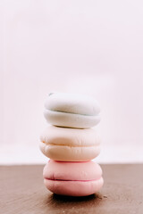 Lots of pink macaroons in a stack on a light background. Macro photography of a group of traditional French round biscuits placed vertically