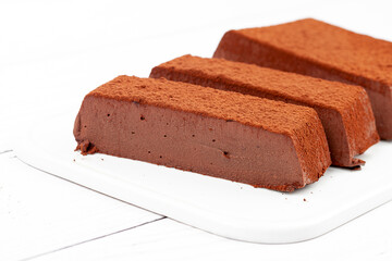 Chocolate mousse cake on a white plate. Soufflé made from cocoa liquor, coconut milk and agar-agar. Vegan desserts