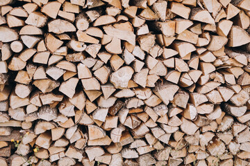 Natural wooden background - close up of chopped firewood. Firewood stacked and prepared for winter Pile of wood logs.