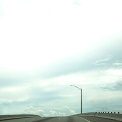 lonely road with lamppost and clouds