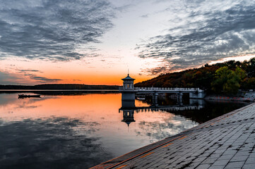 Obraz premium Autumn landscape of Jingyuetan National Forest Park in Changchun, China under the setting sun