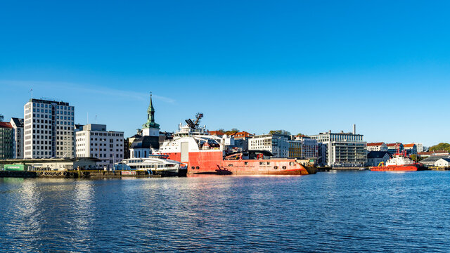 Im Hafen von Bergen, Norwegen, mit Blick auf die Stadt mit ihren H&auml;usern, den Hafenanlagen und Schiffen. sonniger Tag beim Stadtrundgang.