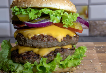 Double burgers with lettuce, tomatoes and cream cheese on wooden board