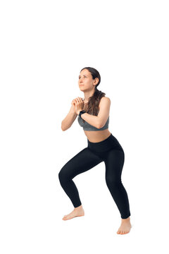 Young woman is performing squats. Full body length photo.