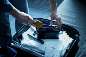 A man businessman collects things in a suitcase for a long business trip. Packing things before...