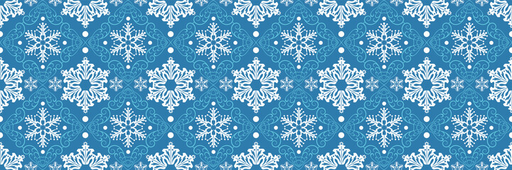 Christmas background pattern with decorative snowflakes on blue backdrop. Seamless background for wallpaper, textures.