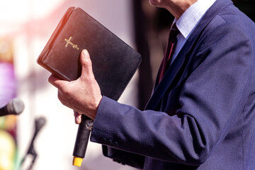 Pastor with a Bible in his hand during a sermon. The preacher delivers a speech