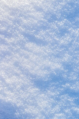 Snowy background, snowy surface with a clearly expressed texture of snow in the morning sun