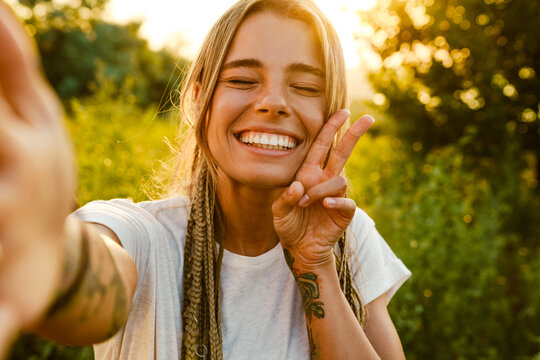 White young woman laughing and gesturing while taking selfie photo