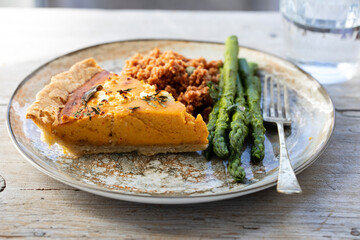 Pumpkin tart with feta cheese and herbs, asparagus and couscous