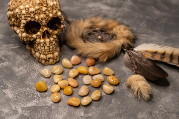 The concept of horoscopes and fortune-telling. Magic stones. Astrology and esoterism. Stones with the sign of the zodiac. Stone runes and pouch on concrete gray background. Top table view and close-up
