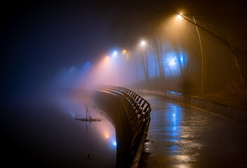 Autumn embankment at night. Heavy fog.