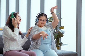 Down syndrome girl is listening to music and singing with her mother during her holiday home.