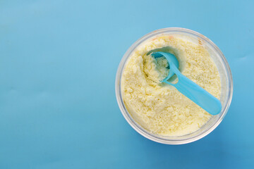 baby milk powder in a container on blue background 