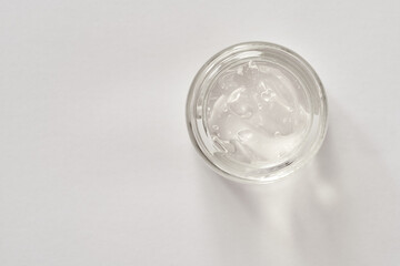Aloe vera gel in a glass jar on white background, top view. Natural skin moisturizer.