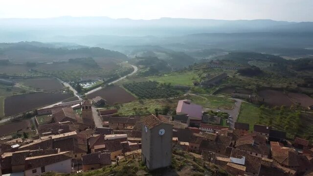 A 360 degrees spiral drone view over the clock tower on top of the hill in Monroyo, Spain