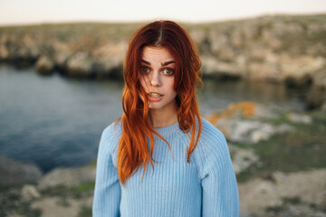 red-haired woman in sweater outdoors travel fresh air