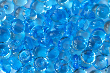 Transparent blue glass marble beads. Acrylic ice stones for decoration. Water drops background. Abstract wallpaper or backdrop for web design