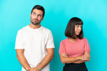 Young couple isolated on blue background with confuse face expression while bites lip
