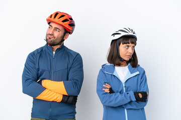 Young cyclist couple isolated on white background with confuse face expression while bites lip