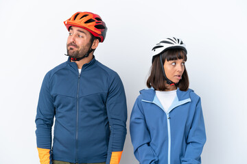 Young cyclist couple isolated on white background nervous and scared