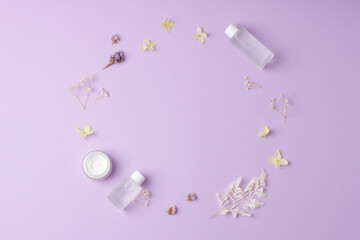 Naklejka na ściany i meble Minimal composition with cosmetic skin care products and flowers on rose. Flat lay, copy space