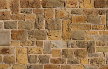 The texture of a old stone wall. Yellow brown tone
