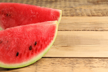 Fototapeta na wymiar Delicious fresh watermelon slices on wooden table, closeup. Space for text