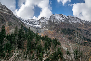 Fototapeta na wymiar nature, landscape, mountains, rocks, snow, snowy peaks, valley, gorge, forest, trees, fir trees, thickets, grass, yellow foliage, expanse, autumn, day, sky, clouds, light, shadow, walk