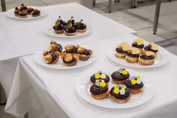 Assortment of delicious fresh shortcrust tart cakes with cream and chocolate on white plate for sale at restaurant, cafe, bakery. Dessert, culinary, sweet food and confectionery concept