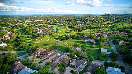 A bird's-eye view of the surroundings of residential buildings and beautiful green fields. Houston, Texas, USA. Development of suburban housing construction. general plan - Powered by Adobe