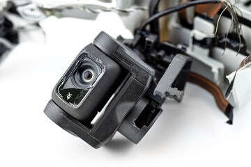 Macro shot of the 4k lens on a damaged drone after a fall with broken cables, isolated on a white background.