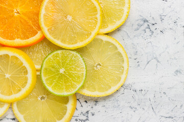 Sliced citrus fruits on concrete background with copy space. Sliced oranges, limes and lemons background